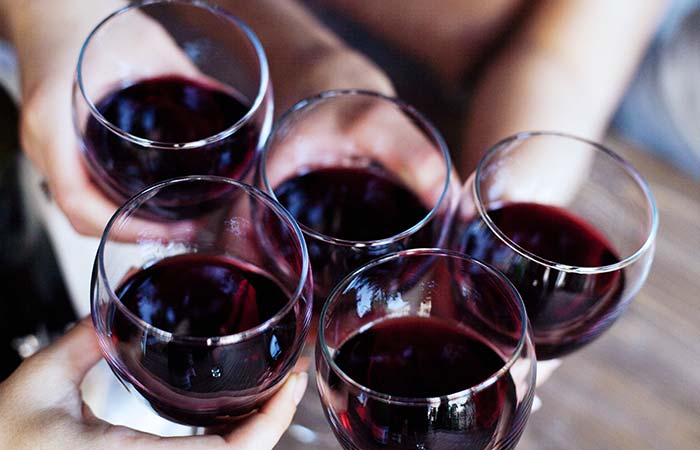 Five people at Torey’s Restaurant & Bar in Owatonna clinking glasses of red wine in celebration.