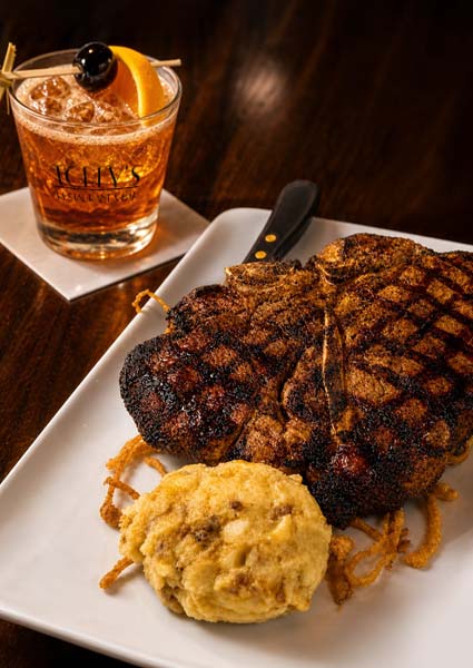 Grilled steak, biscuit, and cocktail with orange slice; enjoy in Owatonna on a crisp white napkin.